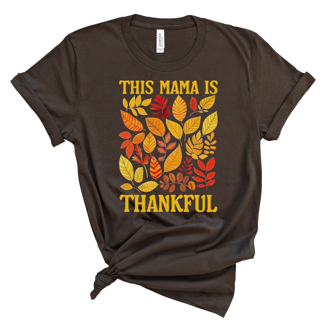 A brown t-shirt with a graphic print of autumn leaves and the text 'THIS MAMA IS THANKFUL'.