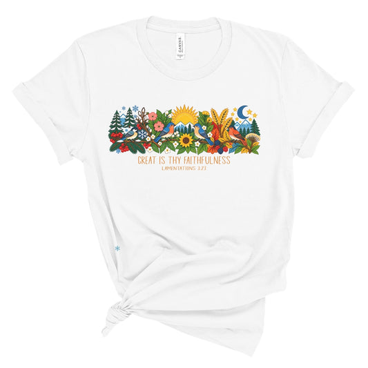 tee with colorful birds, flowers, evergreens, mountains, snowflakes, sun, moon, and the words “Great Is Thy Faithfulness” and “Lamentations 3:23.”