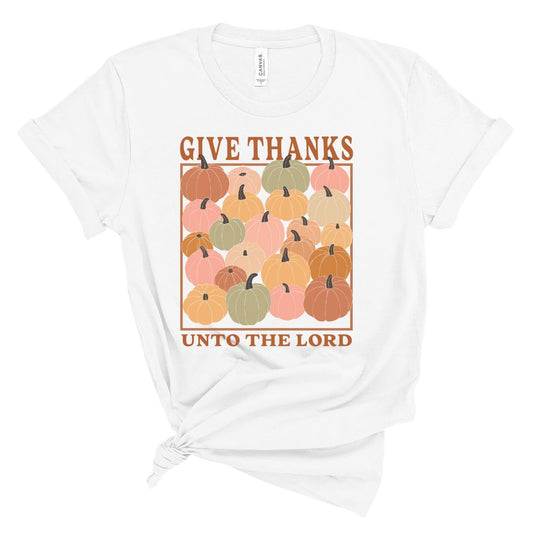 White t-shirt with colorful pumpkins and 'Give Thanks Unto The Lord' text on a white background