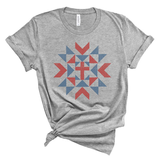 Christian women’s t shirt with vintage red white and blue quilt star pattern surrounding a cross design, patriotic faith based summer graphic tee.