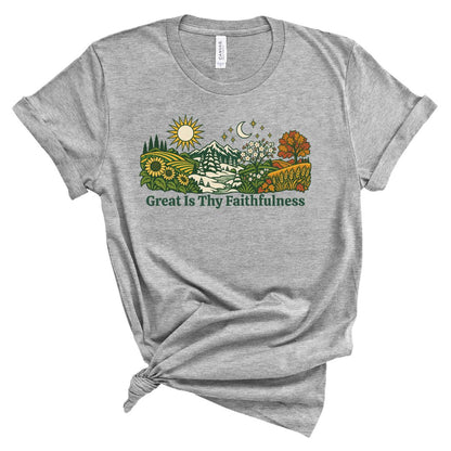 tee with colorful birds, flowers, evergreens, mountains, snowflakes, sun, moon, and the words “Great Is Thy Faithfulness”