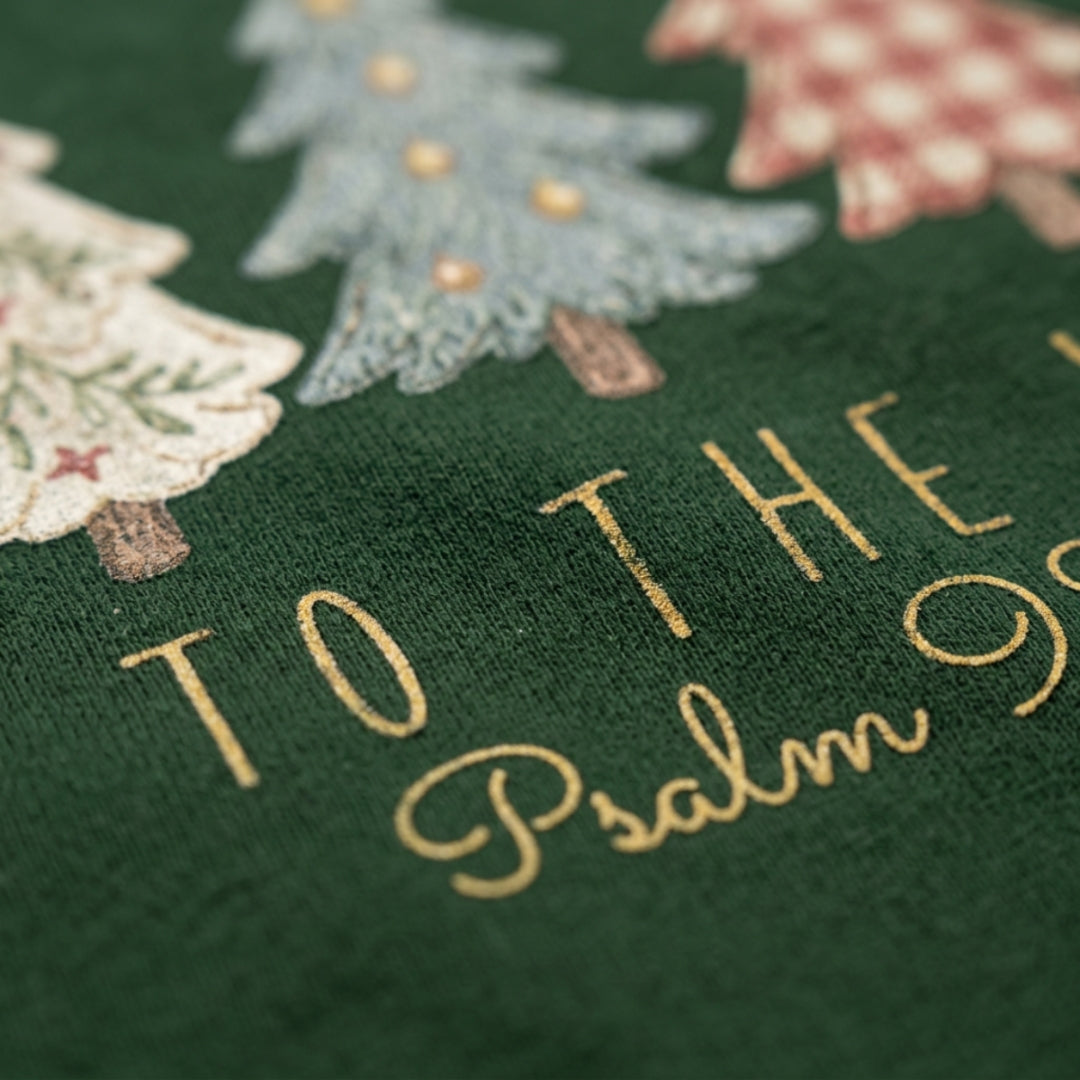 Christian Christmas tee with five decorative Christmas trees in a printed faux embroidery style, with Joy to the World and Psalm 98:4 below.
