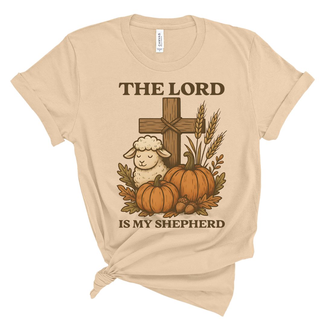 Beige t-shirt with a graphic of a cross, sheep, pumpkins, and wheat with 'The Lord is my Shepherd' text.