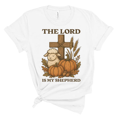 White t-shirt with a graphic of a cross, sheep, pumpkins, and wheat with 'The Lord is my Shepherd' text on a white background.