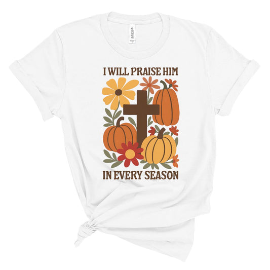 White t-shirt with pumpkins, flowers, and cross design on a white background