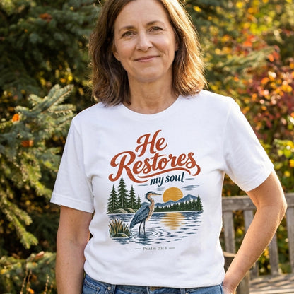 Christian T shirt with “He Restores My Soul,” Psalm 23:3, and a vintage heron, lake, mountain, evergreen, and sunset design.