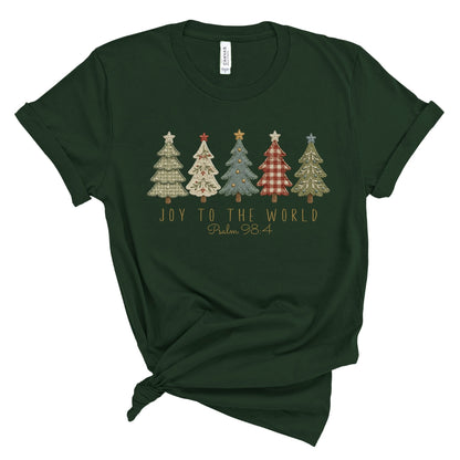 A dark forest green short-sleeve t-shirt with a knotted hem, featuring a graphic of five patterned Christmas trees and the text 'JOY TO THE WORLD Psalm 98' printed on the chest.