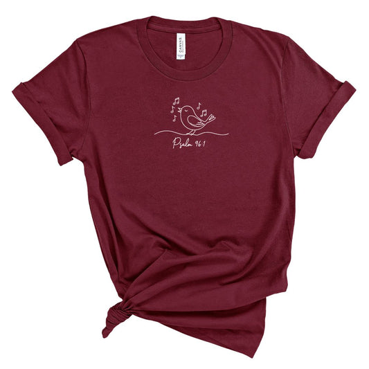 Maroon t-shirt with a bird and musical notes and text psalm 96: design on a white background