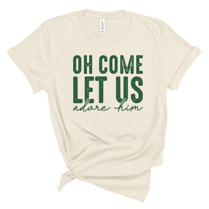 Beige t-shirt with green text 'Oh come let us adore him' on a white background