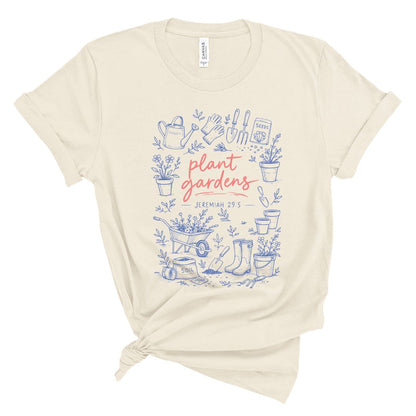 Christian t shirt with blue garden illustrations and coral text reading plant gardens Jeremiah 29:5, Bible verse gardening shirt for women