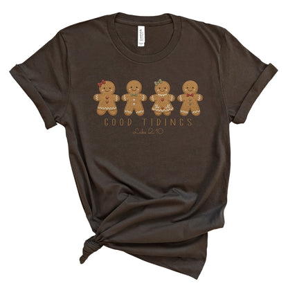 Christian Christmas tee with four gingerbread characters in a printed faux embroidery style, with Good Tidings and Luke 2:10 underneath.