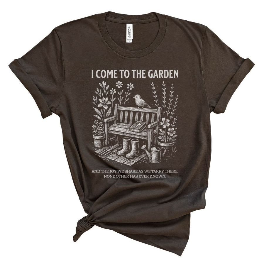 Brown t-shirt with garden graphic and textthat says I come to the garden and the joy we share as we tarry there none other has ever known