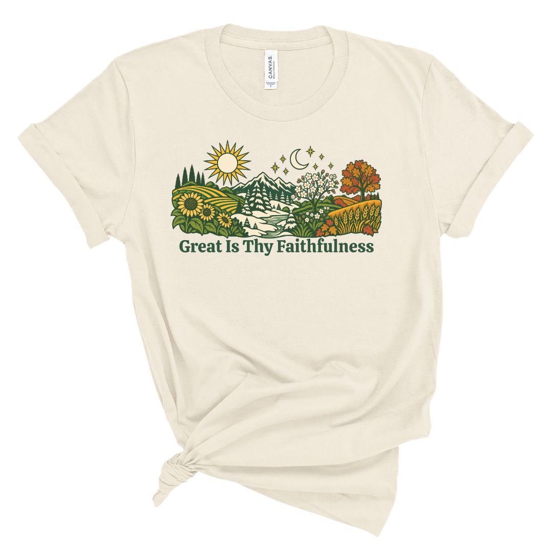 An off-white short-sleeve t-shirt with a graphic of a scenic landscape and the text 'Great Is Thy Faithfulness' printed on the front, styled with a knot at the bottom hem.