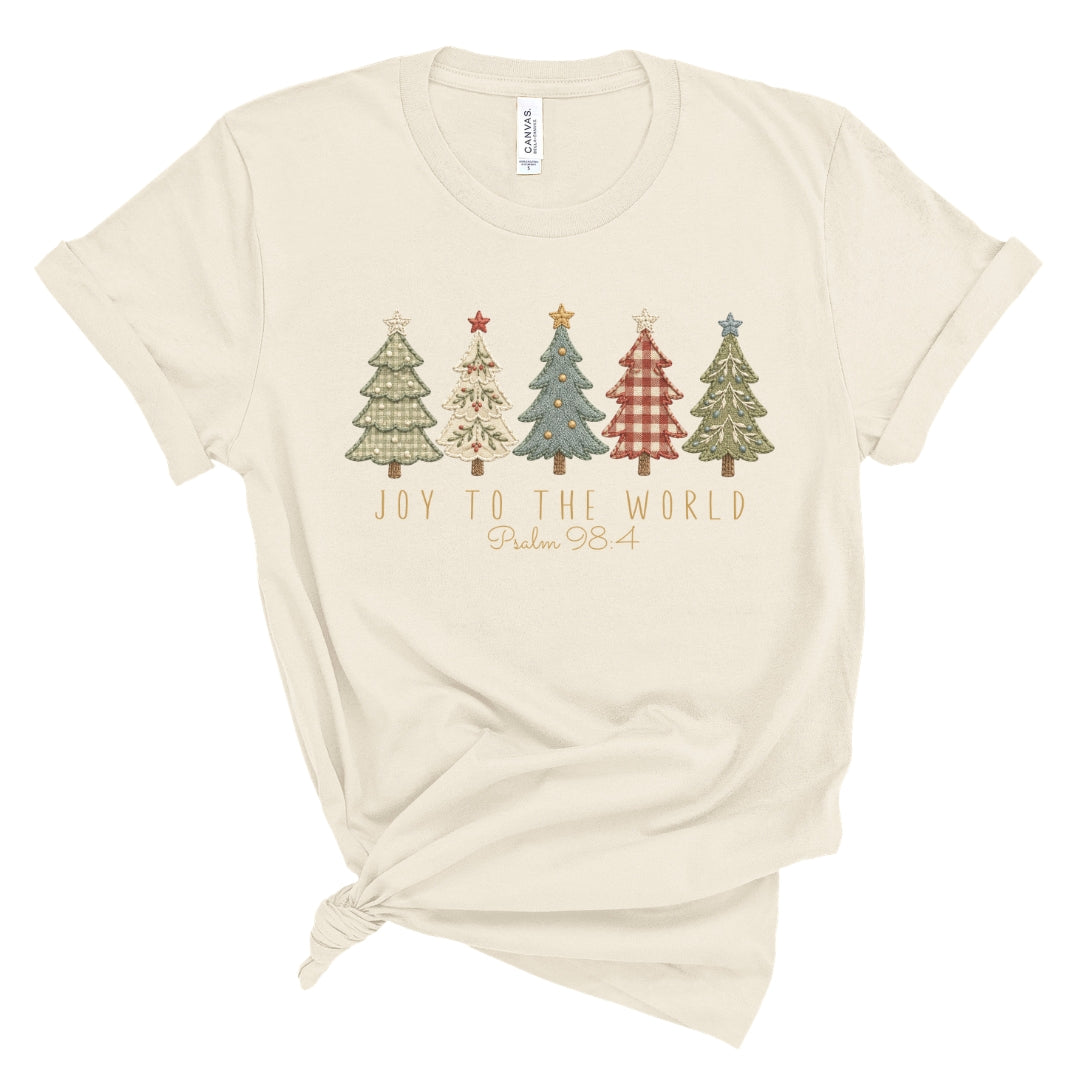 Christian Christmas tee with five decorative Christmas trees in a printed faux embroidery style, with Joy to the World and Psalm 98:4 below.