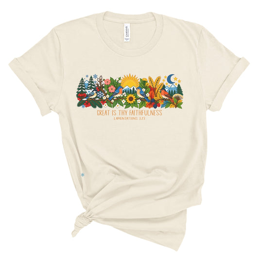 tee with colorful birds, flowers, evergreens, mountains, snowflakes, sun, moon, and the words “Great Is Thy Faithfulness” and “Lamentations 3:23.”