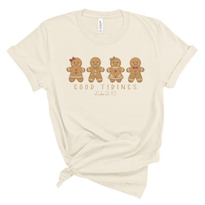 Christian Christmas tee with four gingerbread characters in a printed faux embroidery style, with Good Tidings and Luke 2:10 underneath.