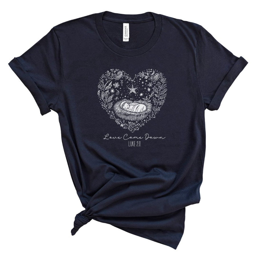 A navy blue t-shirt with a white graphic design of a heart and stars around the center, with the text 'Love Come Down' and Luke 2:11