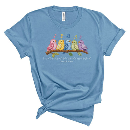 Christian t shirt featuring colorful faux embroidery quilt style birds singing on a branch with the Bible verse I will sing of the goodness of God, Psalm 89:1.