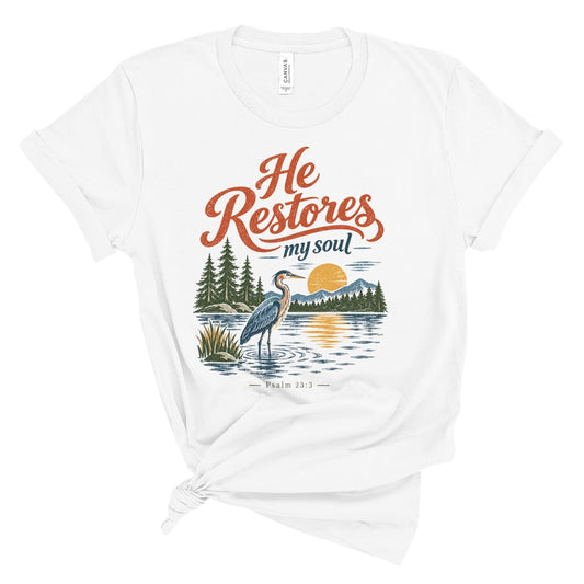 Christian T shirt with “He Restores My Soul,” Psalm 23:3, and a vintage heron, lake, mountain, evergreen, and sunset design.