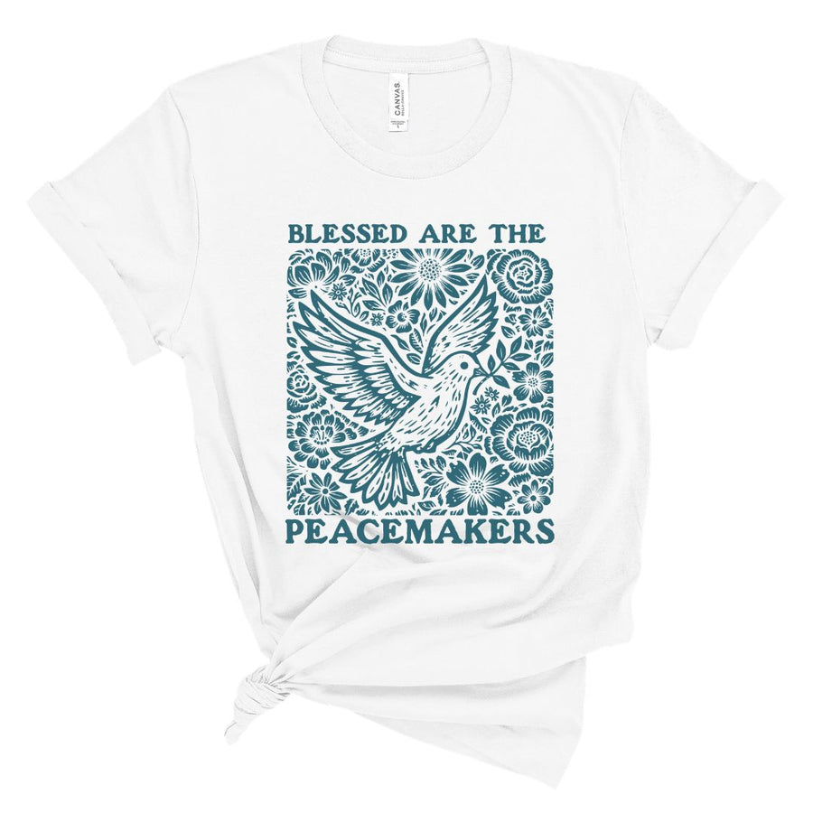 Christian t shirt for women with teal dove and floral design and the words Blessed Are the Peacemakers in bold lettering.
