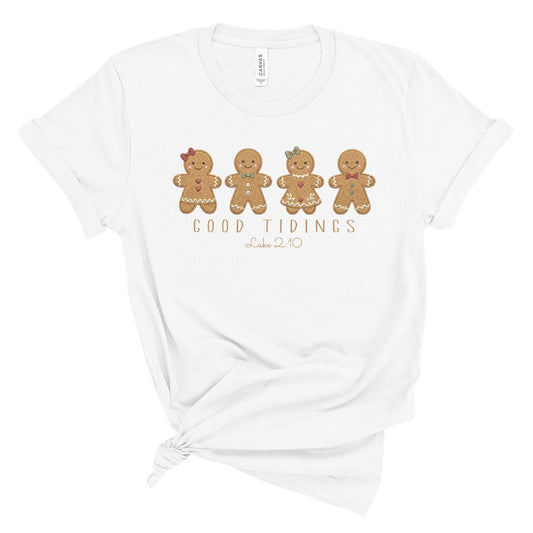 Christian Christmas tee with four gingerbread characters in a printed faux embroidery style, with Good Tidings and Luke 2:10 underneath.