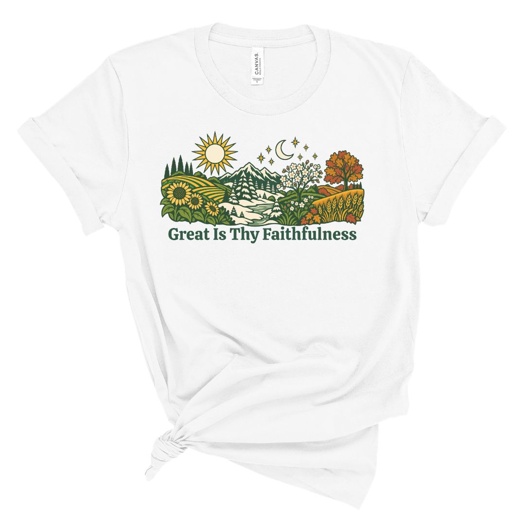 A white short-sleeve t-shirt with a graphic of a scenic landscape and the text 'Great Is Thy Faithfulness' printed on the front, styled with a knot at the bottom hem.